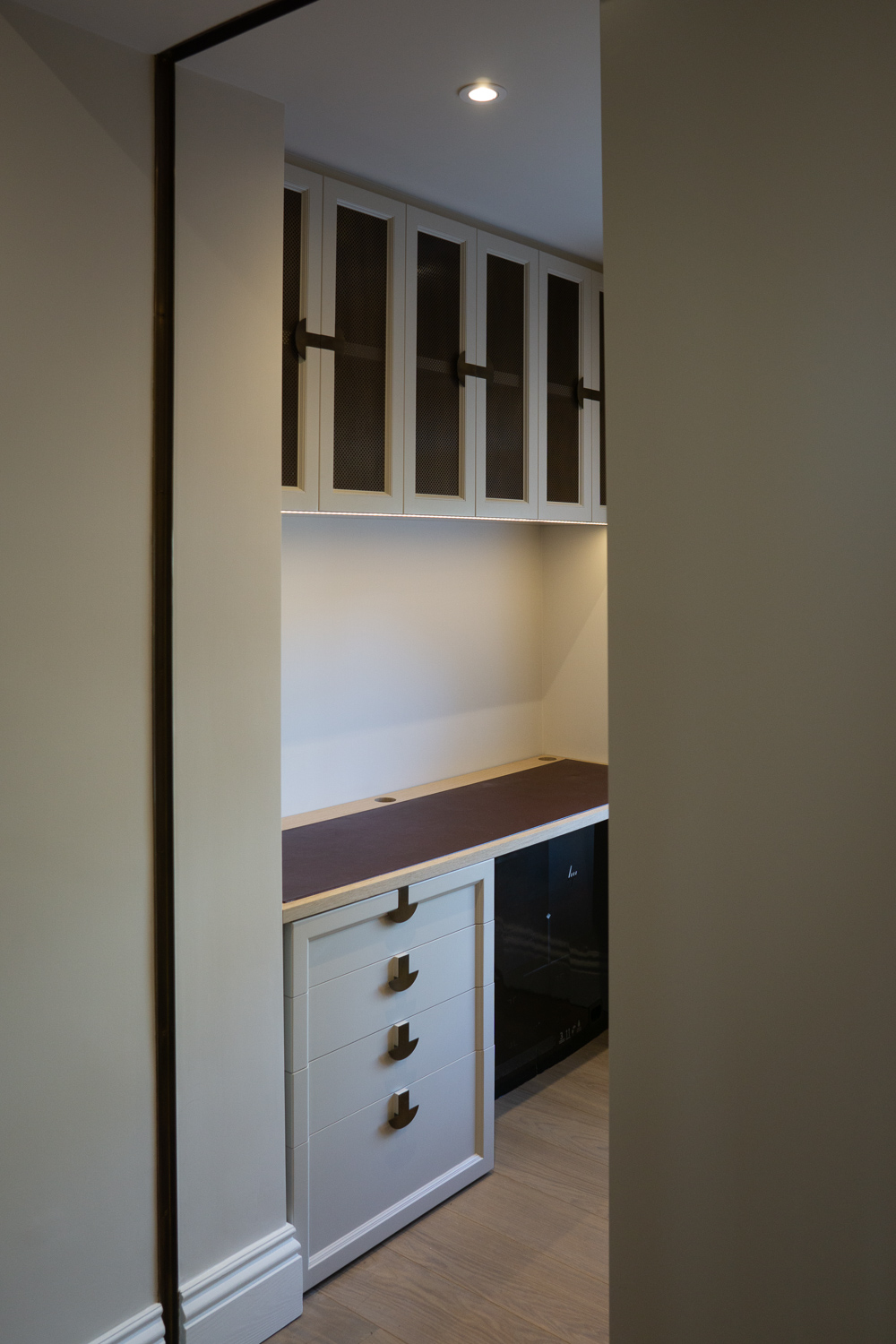 Office Entrance, Cabinets with underlighting. Oak desk with inset leather padding. Bespoke drawer unit with custo designed handles.
